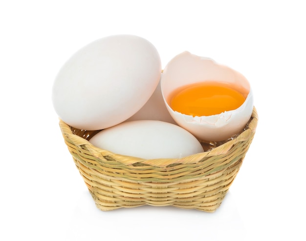 Kacze jajko w koszu bomboo na białym tle.