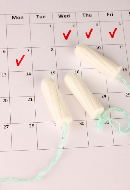 Zdjęcie kalendarz menstruacyjny z zbliżeniem tamponów bawełnianych