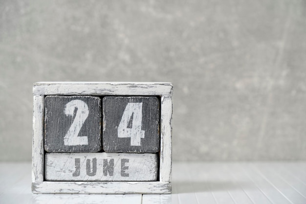Kalendarz na 24 czerwca wykonał drewniane kostki na lekkiej betonowej ścianie z pustym miejscem na tekst
