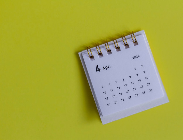 Kalendarz na biurko na kwiecień 2022 na żółtym tle