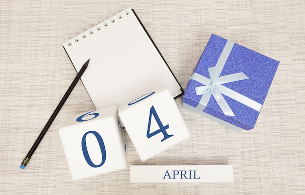 Kalendarz z modnym niebieskim tekstem i cyframi na 4 kwietnia oraz prezentem w pudełku.