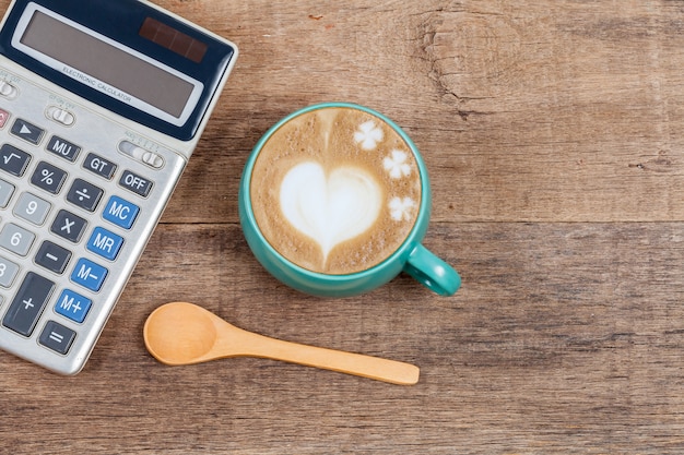Kalkulator i filiżanka kawy na drewnie
