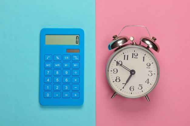 Kalkulator z budzikiem na różowo-niebieskim pastelu. Powrót do szkoły. Koncepcja edukacji