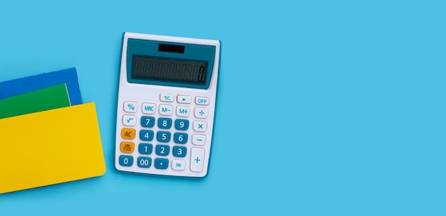 Kalkulator z książkami bankowymi na niebieskim tle