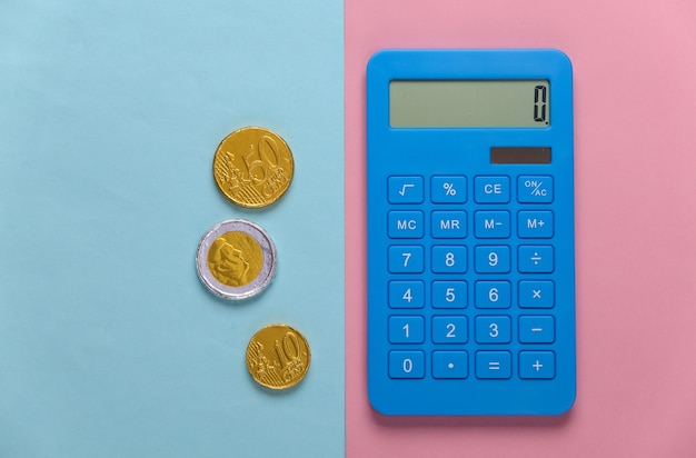Kalkulator z monetami na różowym niebieskim pastelu