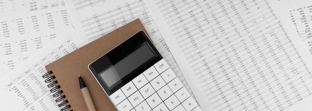 Kalkulator z notatnikiem na sprawozdaniu finansowym