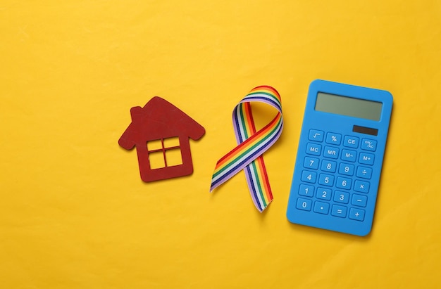 Kalkulator z symbolem taśmy dumy wstążki tęczy LGBT domu na żółtym tle