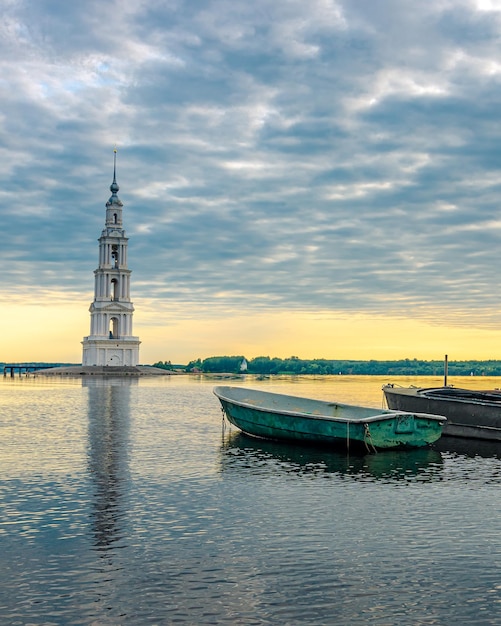 Zdjęcie kalyazin, rosja. dzwonnica katedry św. mikołaja i łodzie rybackie wczesnym rankiem.