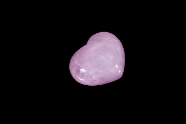 Kamień mineralny makro Serce różowy kwarc na czarnym tle z bliska