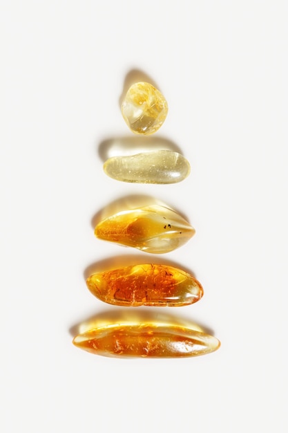 Kamienie bursztynowe w rzędzie na beżowym tle neutralnym przezroczysty kamień żółty beżowy kolor