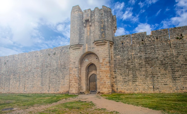 Kamienna ściana europejskiego zamku z bramą w miękkim świetle słonecznym
