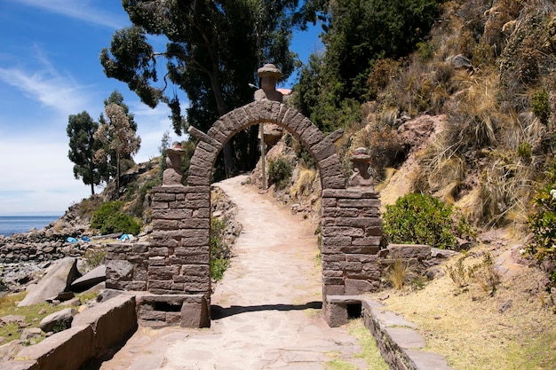 Kamienne głowy wyrzeźbione w łukach na wyspie Taquile na jeziorze Titicaca w Peru