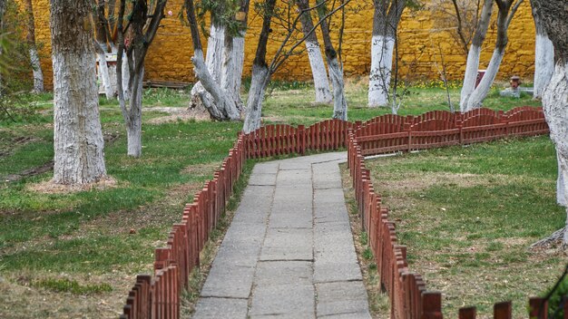 Zdjęcie kamienny sposób w ogródzie z czerwieni ogrodzeniem