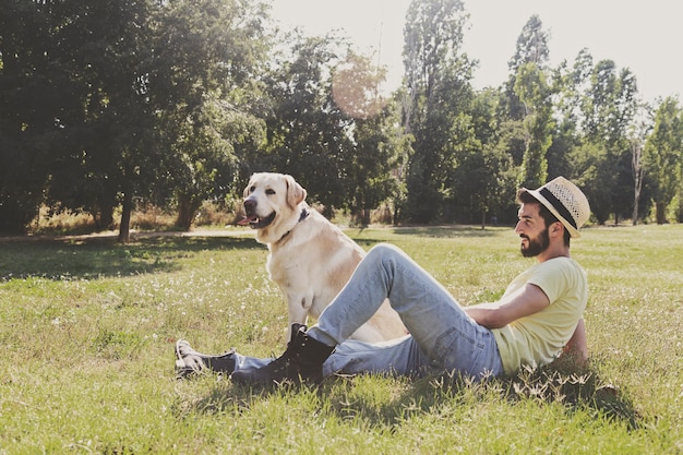 Kanadyjski pies labrador odpoczywa w parku ze swoim właścicielem w słoneczny dzień