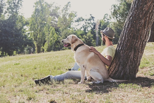 Kanadyjski pies labrador odpoczywa w parku ze swoim właścicielem w słoneczny dzień