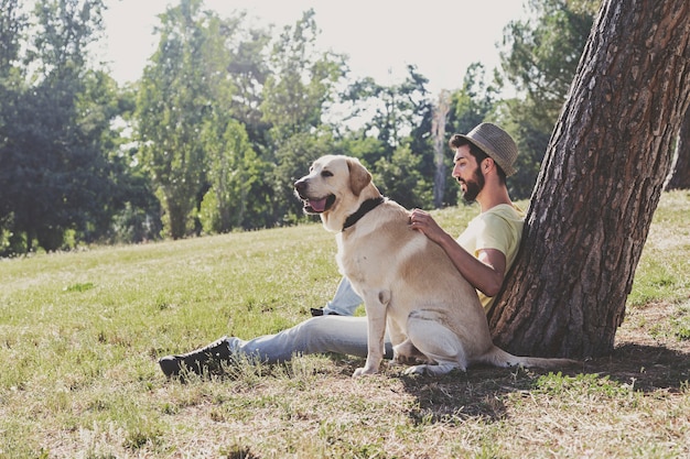 Kanadyjski pies labrador odpoczywa w parku ze swoim właścicielem w słoneczny dzień