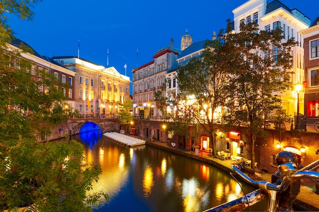 Kanał Oudegracht i most w kolorowych iluminacjach nocą, Utrecht, Holandia