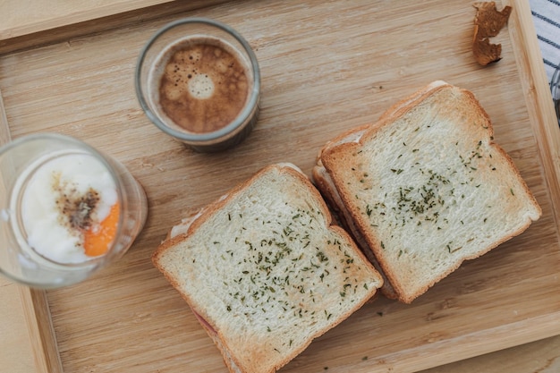 Kanapka z jajkami na miękko i jednym kieliszkiem kawy espresso jako śniadanie