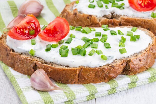 Zdjęcie kanapka z serkiem cebulowym i pomidorami