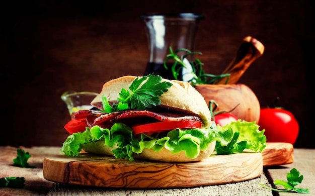 Kanapka z szynką, sałatą i pomidorem w bułce pszennej vintage drewniane tło selektywne focus