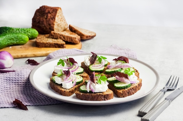 Kanapki z chlebem tostowym ze słonecznikiem i nasionami lnu, ser feta, ogórek i cebula