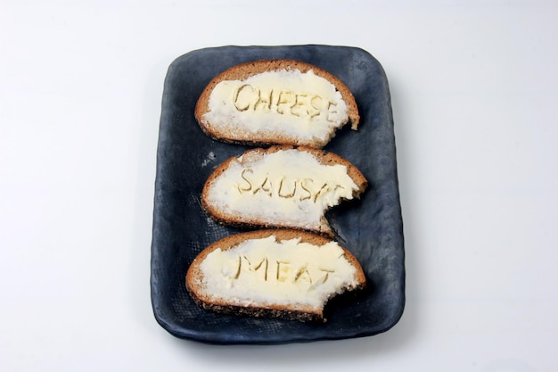 Kanapki z napisem mięso, kiełbasa, ser na maśle. Symbolizuje kryzys żywnościowy