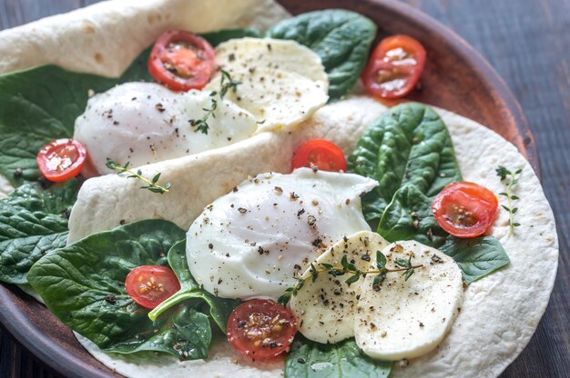 Kanapki z tortilli z jajkiem w koszulce, mozzarellą, szpinakiem i pomidorkami koktajlowymi