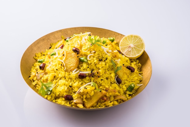 Kande Pohay OR Aloo Poha to popularny indyjski przepis na śniadanie przyrządzane przy użyciu spłaszczonego ryżu, zwykle podawane z gorącą herbatą. Podawane w misce powyżej . Selektywne skupienie