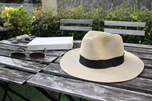 Zdjęcie kapelusz fedora, okulary i książki na zewnątrz drewniany stół chłodzenie dzień