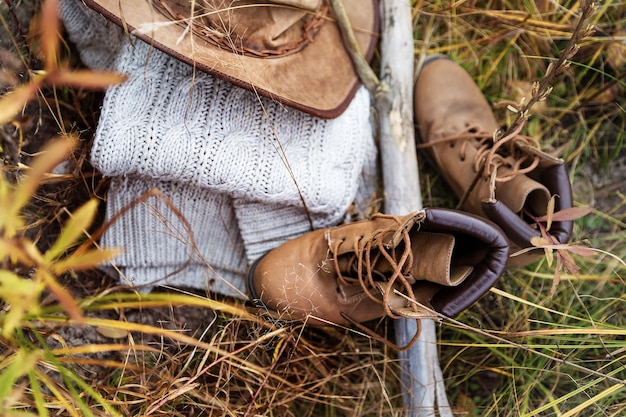 Kapeluszowy sweter i buty leżą na trawie