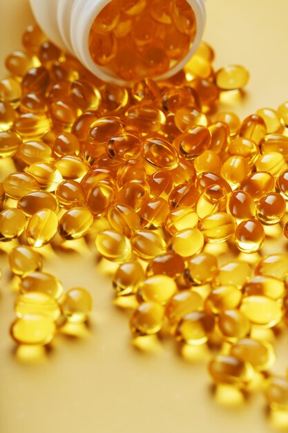 Kapsułki Gold Vitamin D3 nalewane ze słoika na żółtym tle z wolną przestrzenią Najważniejsza witamina w łatwo przyswajalnej płynnej postaci