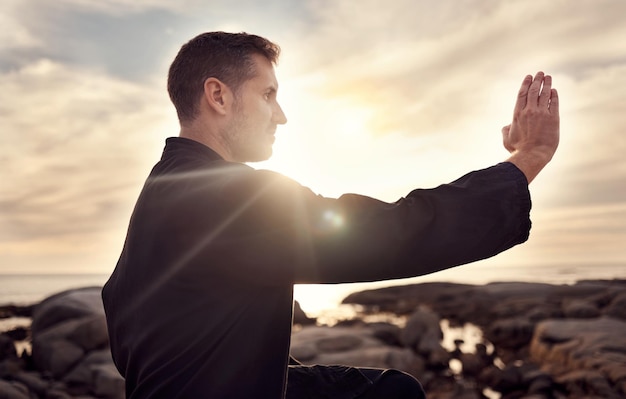 Karate man sztuki walki i trening tai chi do walki na plaży z pochmurnym niebem zachodu słońca dla skupienia mocy i energii na świeżym powietrzu Mężczyzna wojownik gotowy do walki sportowej i ćwiczeń dla sprawności na morzu