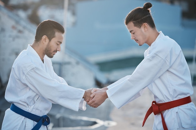 Karate męskie i uścisk rąk podczas treningu walka z szacunkiem fitness i rozpoczęcie treningu konkurs na rozwój sztuki walki trenowanie razem lub pokój do ćwiczeń zen mentalność lub sporty walki