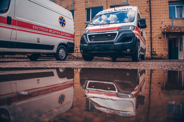 Karetki pogotowia odbijają się w kałuży Napis Karetka pogotowia