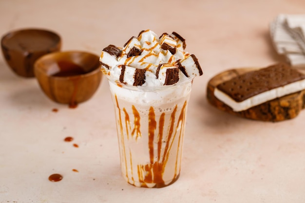 Karmelowe frappe z kanapką z lodami i czekoladą podawane w szklance wyizolowanej na deserze kawiarnianym na stole Frappuccino Napój mieszany