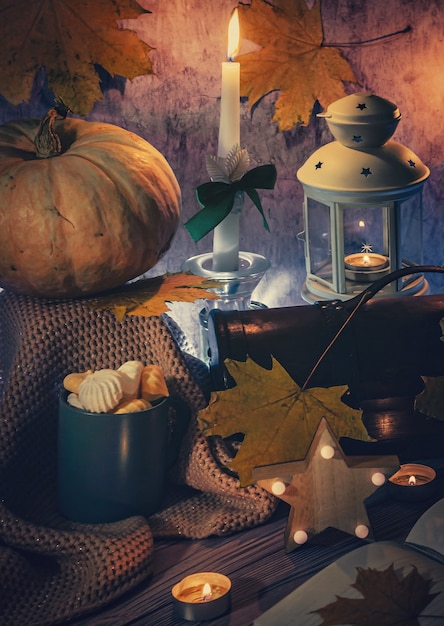 Karta Halloween, fotografia pionowa, dynia, latarnia płonące świece i słodycze, ciemne tło.