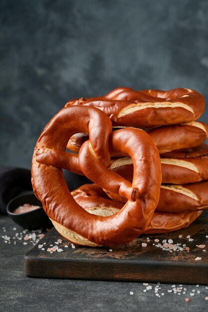 Karta koncepcyjna Oktoberfest Tradycyjne bawarskie precle z kuflem piwa na starym ciemnoczarnym rustykalnym tle Idealne na menu Oktoberfest Oktoberfest