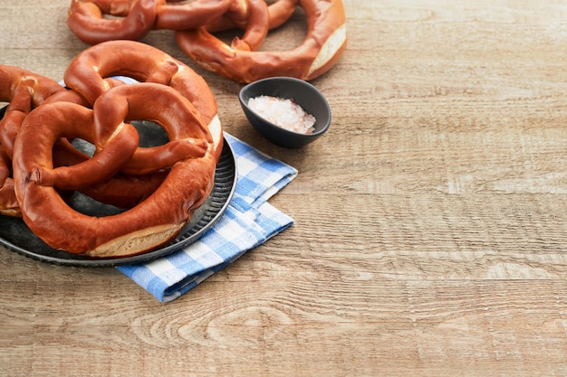 Karta koncepcyjna oktoberfest Tradycyjne bawarskie precle z kuflem piwa na starym rustykalnym drewnianym tle Idealne na październikowe menu Oktoberfest Widok z góry Makieta