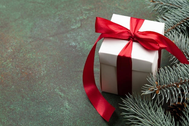 Karta świąteczna z choinką i pudełkiem podarunkowym na kamiennym tle i kopiowanie miejsca dla twoich świątecznych życzeń