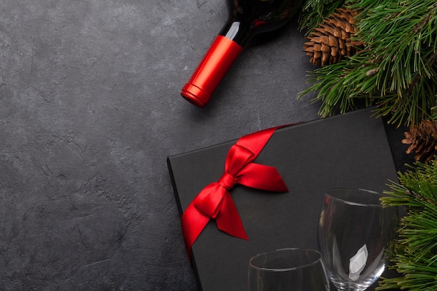 Karta świąteczna z winem z jęczmienia i pudełkiem podarunkowym na kamiennym tle Top view flat lay z miejscem dla twoich świątecznych życzeń