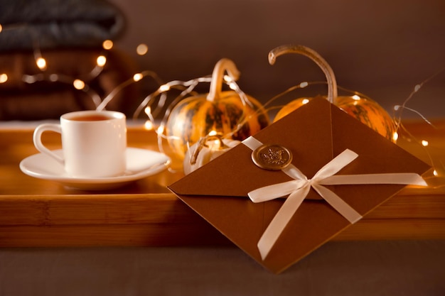 Zdjęcie kartka podarunkowa na prezent świąteczny drewniana tacka z kawą z dyni i świąteczna koperta