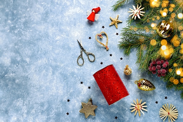 Kartka świąteczna z gałęzi jodłowych, czerwonymi wstążkami i dekoracjami, drewnianymi ornamentami, konfetti ze śniegiem. Świąteczne mieszkanie leżało