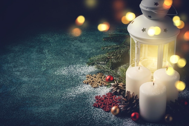 Zdjęcie kartka świąteczna ze świecącą świeczką i latarnią na niebieskim tle