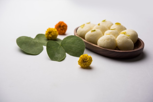 Zdjęcie kartka z życzeniami happy dasera, vijayadashami, ayudh puja z użyciem apta lub bauhinia racemosa, liścia bidi i indyjskiej słodkiej rasgulla dla nawaratri