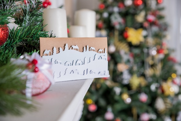 kartkę z życzeniami nowego roku na półce. MAJSTERKOWANIE . Śnieżny krajobraz, nadchodzi zima. Minimalistyczny papierowy styl. Krajobraz śnieżnej wsi. Streszczenie projektu.