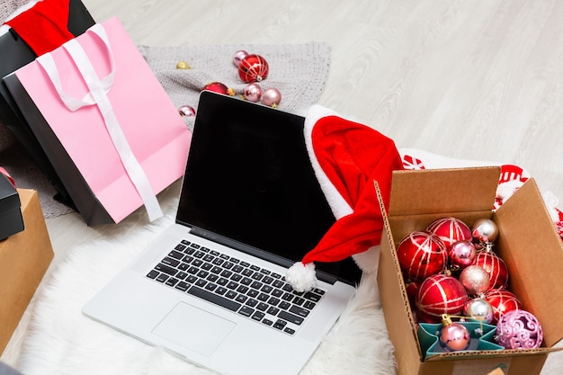 Kartkę z życzeniami świątecznymi, pudełka na prezenty, laptop i filiżankę kawy na drewniane tła. Widok z góry z miejscem na kopię tekstu