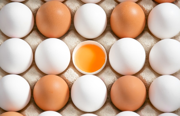 karton z jajami z białym i brązowym jajkiem i jajkiem otwartym w środku