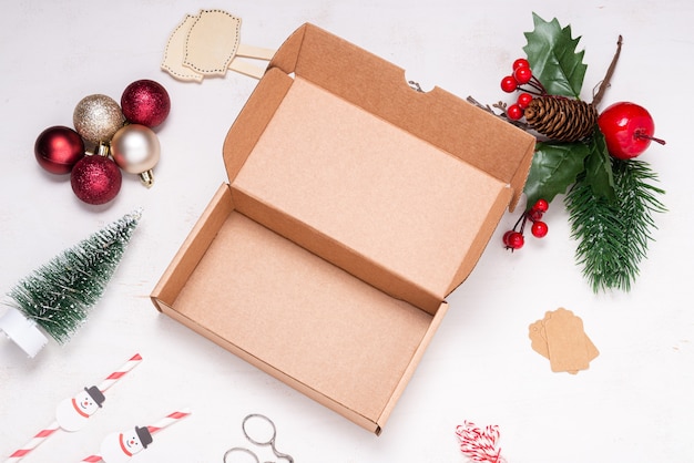Zdjęcie kartonowe pudełko na drewnianym biurku ozdobione świąteczną ozdobą