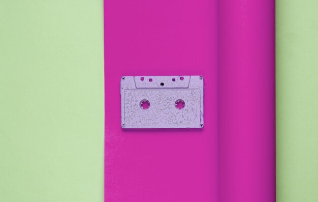 Kaseta audio na owiniętym tle papieru. Trend pastelowych kolorów, minimalistyczna martwa natura w stylu retro z lat 80. Widok z góry