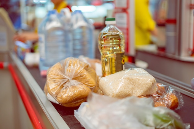 Kasjer supermarketu z jedzeniem na przenośniku do zakupu w weekend